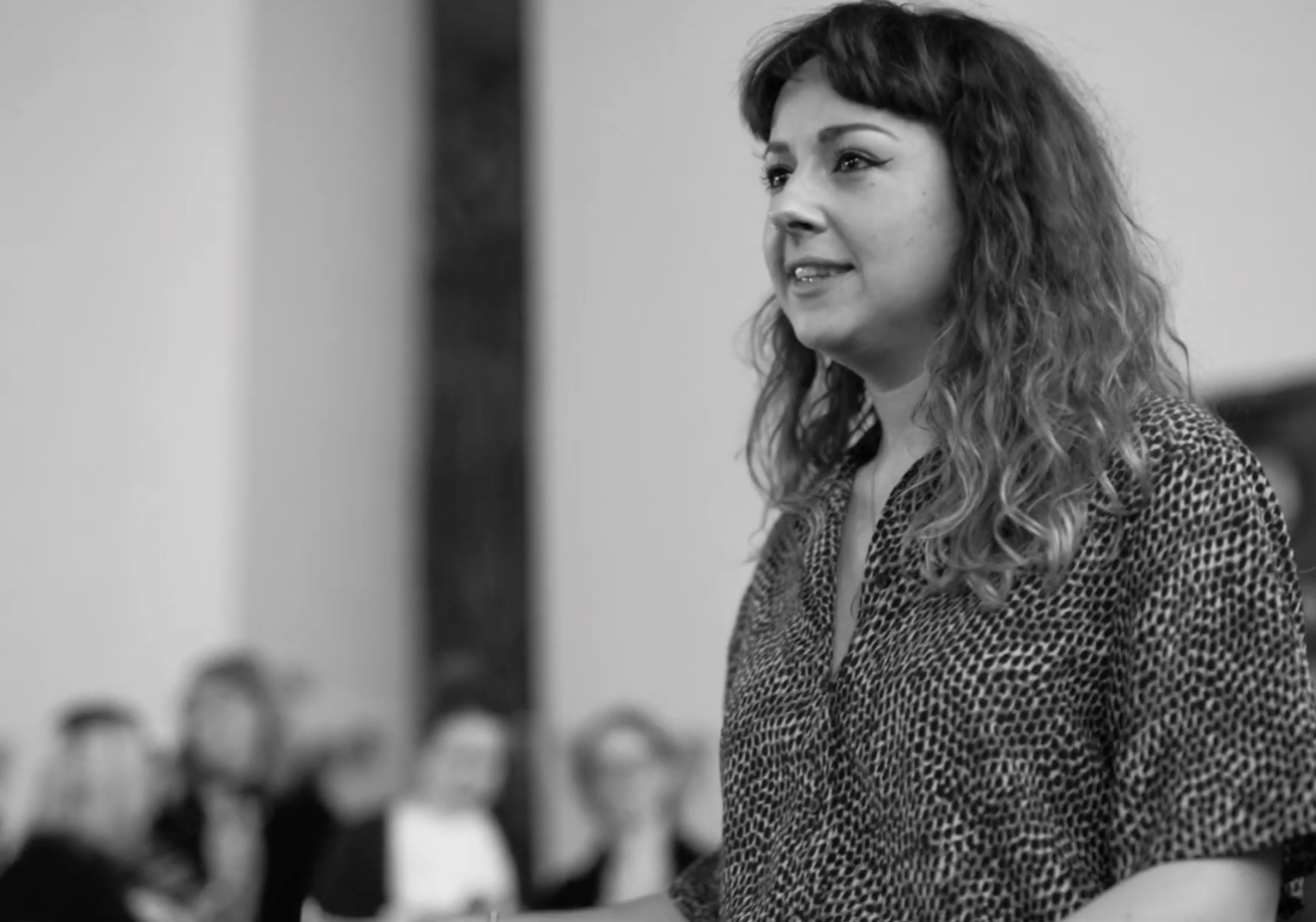 barber using styling spray on young man with black hair, short on sides and long in a quiff on top
